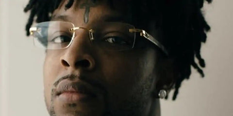 21 Savage is seen wearing rimless Cartier Ibiza CT0052O 005 glasses with wood temple