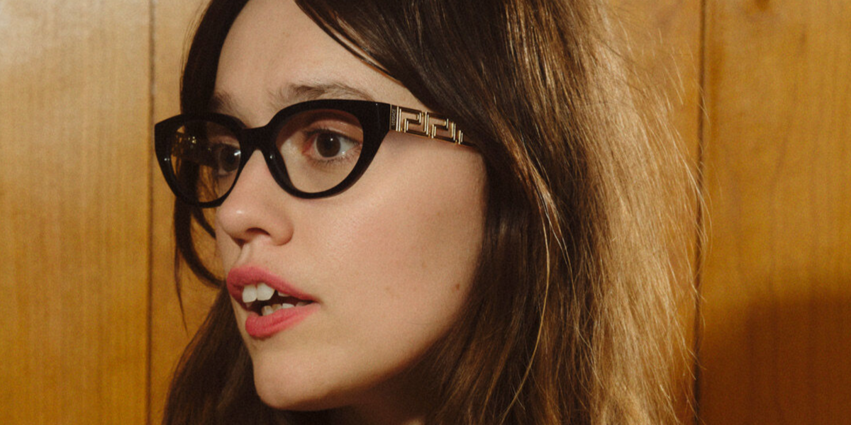 Aimee Lou Wood was seen wearing black Versace 3383 GB1 cat eye optical glasses in the Versace Greca Eyewear campaign, October 2025.