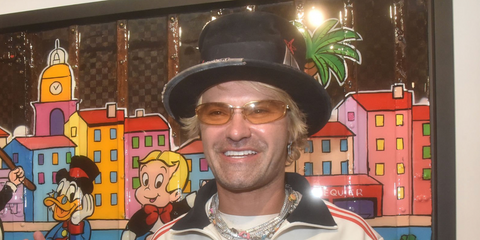 DJ and street artist Alec Monopoly was seen wearing gold Miu Miu MU A50S 5AK7R1 sunglasses with yellow lenses during the Alec Monopoly preview at Eden Gallery Saint-Tropez, July 2025.