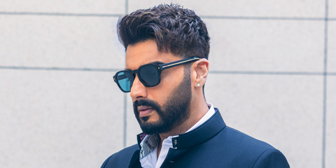 Bollywood actor Arjun Kapoor was seen wearing black Prada PR A16S 16K04D sunglasses with blue Polarised lenses in his Instagram post, April 2026