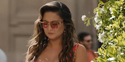 Ashley Park was seen wearing Miu Miu MU 10ZS 15T1D0 sunglasses with pink red lenses in Emily in Paris season 5, episode 2 as Mindy Chen.