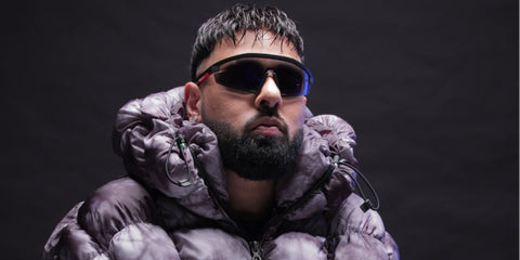 Indian rapper Badshah was seen wearing black Prada Linea Rossa SPS 03Z 1BO10A sunglasses.