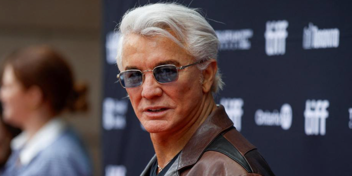 Australian filmmaker and producer Baz Luhrmann was seen wearing pale gold Miu Miu MU A53S ZVN60O rectangular sunglasses with light blue lenses at the Toronto International Film Festival 2025. Shop online now on Pretavoir