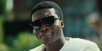 Actor Benjamin Clementine was seen wearing black Persol 3348S 95/31 sunglasses in Netflix series The Gentlemen season 2 as Nanny Asante