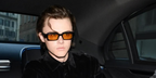 Christopher Briney was seen wearing black Prada PR 27ZS 16K70A rectangular sunglasses with orange yellow lenses to attend the Prada Menswear Fall/Winter 2024 fashion show during Milan Men's Fashion Week