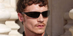 Connor Storrie was seen wearing black Saint Laurent Sun SL 963 001 wraparound sunglasses at the Saint Laurent Menswear Spring/Summer 2027 fashion show during Paris Men's Fashion Week