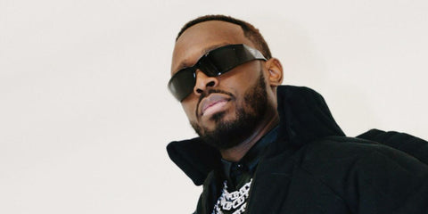 French-Congolese singer Dadju was seen wearing black Prada PR A19S 1AB5S0 wraparound sunglasses. Shop online now on Pretavoir