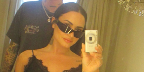Demi Lovato was seen wearing black Prada PR A14S 1AB5S0 wraparound sunglasses in her Instagram mirror selfie, June 2026.