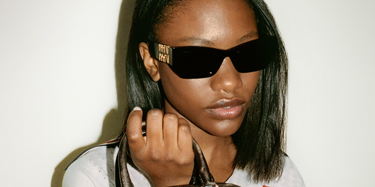 Demi Singleton was seen modeling black Miu Miu MU 09WS 1AB5S0 sunglasses with gold detail and grey lenses in the Miu Miu Fall/Winter 2022 campaign