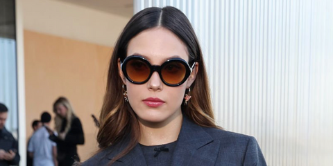 Freestyle skier and model Eileen Gu was seen wearing black Prada PR D08SU 16K10X round sunglasses with brown gradient lenses at the Prada Fall/Winter 2026 show during Milan Fashion Week.