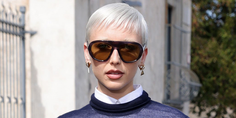 Emma Chamberlain was seen wearing striped tortoise Prada PR C05S 23G70G sunglasses with green olive lenses at the Prada Spring/Summer 2026 fashion show during Milan Fashion Week.