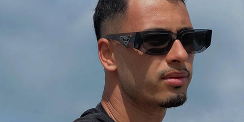 Brazilian footballer Gabriel Martinelli was seen wearing transparent grey Prada PR 09ZS 18S09T sunglasses in his Instagram story.