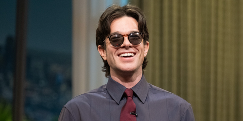 John Mulaney is seen wearing Oliver Peoples O'Malley Sun OV5183S 1005/P1 Black Polarised round sunglasses