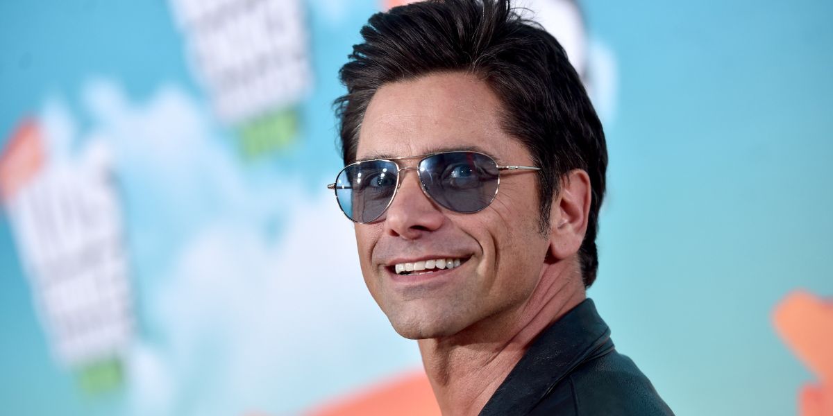 John Stamos is seen wearing Oliver Peoples Benedict OV1002S 5241/3F Silver/Chrome Sapphire Photochromic VFX sunglasses with blue lenses