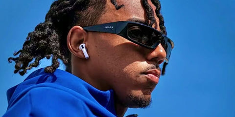 Jules Kounde was seen wearing black Prada PR 25YS 1AB5S0 wraparound sunglasses
