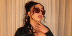 Kali Uchis was seen wearing gold Miu Miu Rimless Runway MU 54YS 5AK06I sunglasses with brown purple lenses at the 2023 Coachella music festival