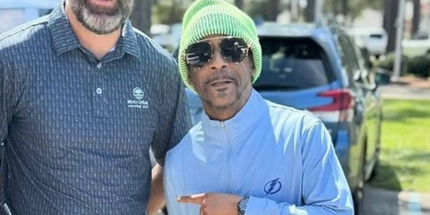 Comedian Katt Williams is seen wearing Versace 2232 1438/87 aviator sunglasses while being photographed with a fan