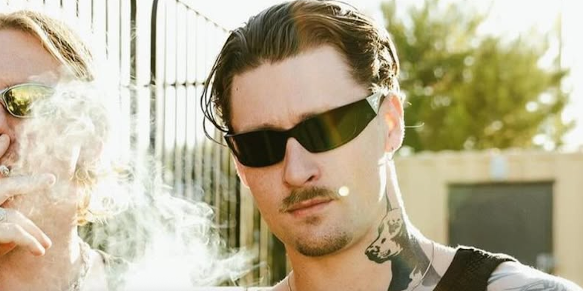 Irish DJ and producer Kettama was seen wearing black Prada PR A19S 1AB5S0 wraparound sunglasses in the promotional image of Cultivate Festival Aberdeen 2024.