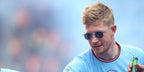 Manchester City player Kevin de Bruyne was seen wearing transparent Oliver Peoples Gregory Peck Sun OV5217S 1101/R8 sunglasses with blue Indigo Photochromic lenses