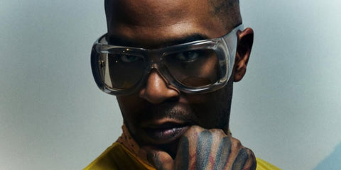 Rapper Kid Cudi was seen wearing transparent Saint Laurent Sun SL 902 HOWL 002 pillowed sunglasses in a Vogue France feature, April 2026.