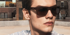 Louis Partridge was seen wearing brown Prada PR D11S 27I90W square sunglasses in the Prada Spring/Summer 2026 campaign.
