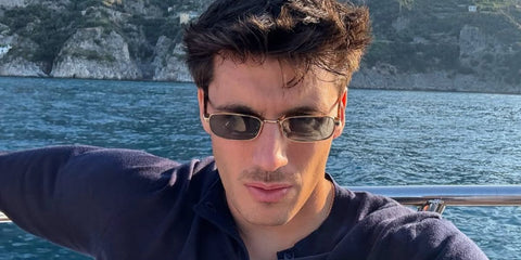 Italian entrepreneur and digital creator Luca Santeramo was seen wearing gold Prada PR B54S 5AK40K rectangular sunglasses with blue lenses in Amalfi Coast, shared through his Instagram post in July 2025.