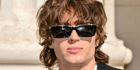 Musician, model, and husband of Anya Taylor Joy, Malcolm McRae, was seen wearing black and gold Saint Laurent SL 766 001 rectangular sunglasses at the Saint Laurent Menswear Spring/Summer 2026 fashion show during Paris Men's Fashion Week. Shop online now on Pretavoir