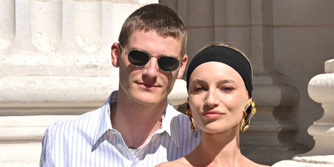 Model Mikkel Jensen, pictured alongside girlfriend Maya Stepper, was seen wearing silver Saint Laurent SL 799 002 round oval sunglasses at the Saint Laurent Menswear Spring/Summer 2026 fashion show during Milan Men's Fashion Week.