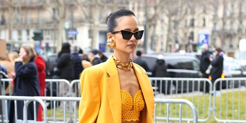 Natasha Poonawalla was seen wearing black Saint Laurent Sun SL 570 001 squared cat eye sunglasses with gold piping to attend the Stella McCartney Fall/Winter 2023 fashion show during Paris Fashion Week