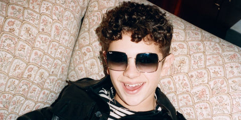 Noah Jupe was seen wearing rose gold Ray-Ban Square RB 1971 9202/51 butterfly square sunglasses with brown to clear gradient lenses in a Dazed Magazine feature