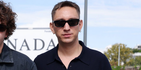 Musician Oliver Sim of The xx was seen wearing black Prada PR B11S 16K731 sunglasses at the Prada Spring/Summer 2026 fashion show during Milan Fashion Week.