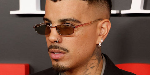 Puerto Rican singer Rauw Alejandro was seen wearing silver Prada PR B54S 1BC30P rectangular sunglasses with light brown lenses at the Time 100 Gala in New York City, April 2026