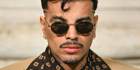 Puerto Rican singer Rauw Alejandro was seen wearing silver Saint Laurent SL 799 002 oval sunglasses at the Saint Laurent Menswear Spring/Summer 2026 during Paris Men's Fashion Week. Shop online now on Pretavoir