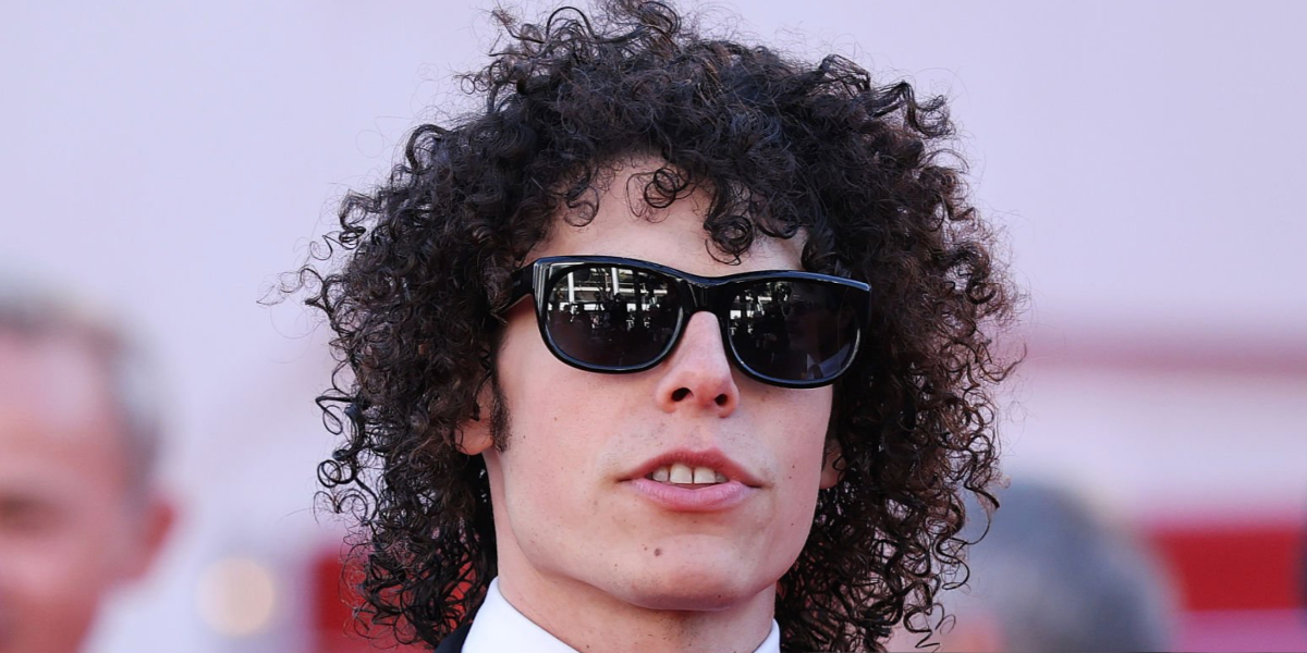 Digital creator Reece Feldman, widely known as Guy With A Movie Camera, was seen wearing black Saint Laurent Sun SL 815 Romy 001 sunglasses at the Karma screening during Cannes Film Festival 2026.