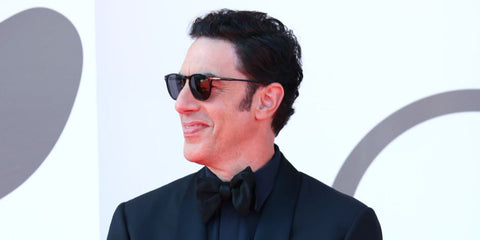 Actor and comedian Sacha Baron Cohen was seen wearing black David Beckham DB 1160/S 807IR sunglasses with grey lenses at the Venice Film Festival 2024. Shop online now on Pretavoir
