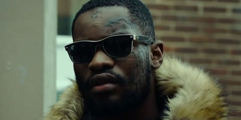 Rapper Santan Dave was seen wearing black and beige Ray-Ban New Wayfarer 2132 875 Color Mix sunglasses in 2019 Netflix show Top Boy.