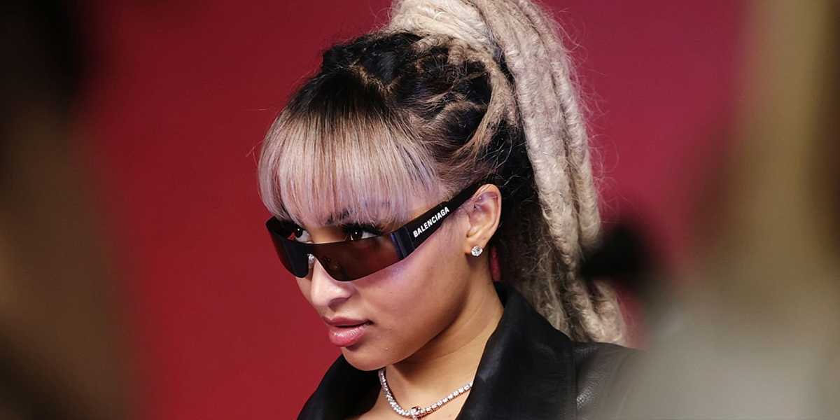 Jamaican singer Shenseea wre black Balenciaga BB0041S 001 wraparound sunglasses at the 2026 iHeartRadio Music Festival.
