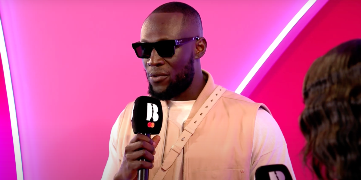 Stormzy was seen wearing black Prada PR 19WS 1AB5S0 square sunglasses to attend the 2025 Brit Awards