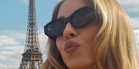 Sydney Sweeney poses next to Eiffel Tower wearing Versace 4470B GB1/87 Sunglasses.