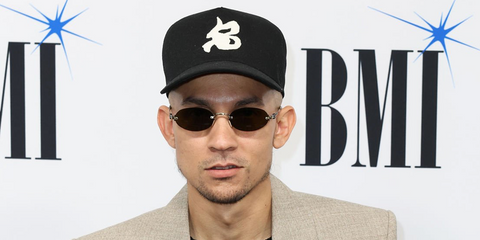 Puerto Rican singer Tainy was seen wearing antique gold Miu Miu MU A54S 26C09Z oval sunglasses with dark brown lenses at the BMI Latin Awards 2026.