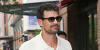 Theo James wore black Barton Perreira Remi BP40120I 01B sunglasses with grey gradient lenses in October 2026.