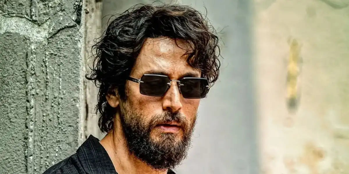 Bollywood actor Tiger Shroff was seen wearing black and ruthenium David Beckham DB 7109/S 85KIR rimless sunglasses