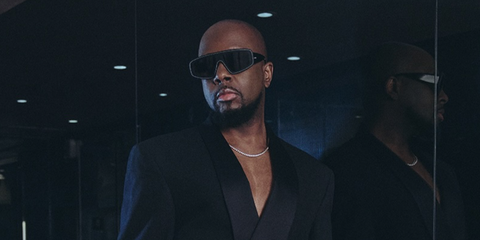 Wyclef Jean was seen wearing black acetate and leather Alaia AA0095S 001 sunglasses with white stitch detailing in a Haute Living New York magazine feature, April-May 2026 issue.