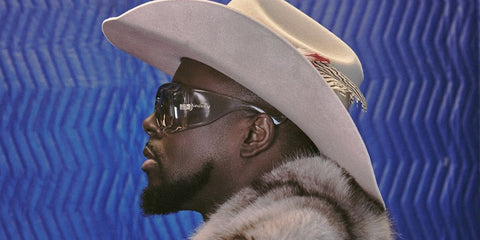 Wyclef Jean was seen wearing transparent Saint Laurent Sun SL 902 HOWL 002 pillowed sunglasses in an Haute Living New York magazine feature, April-May 2026 issue.